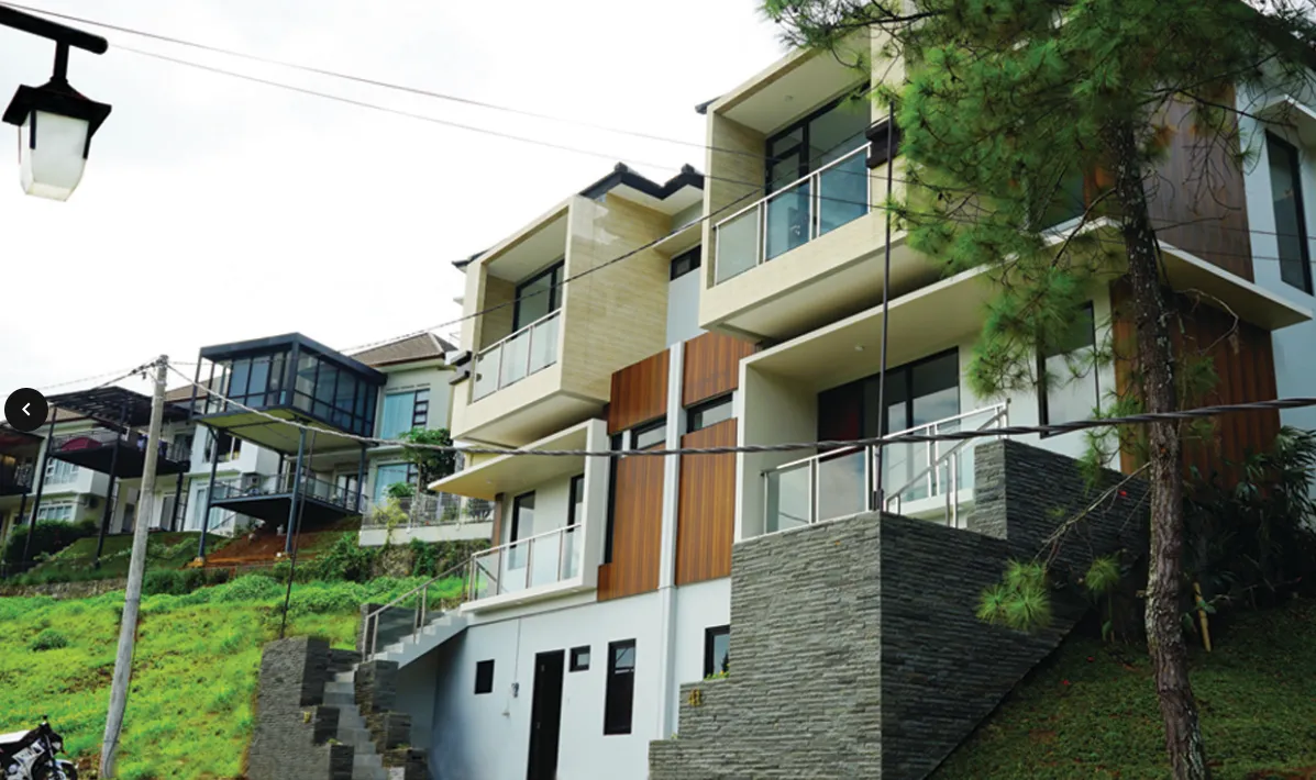 Desain rumah modern tropis di Resor Dago Pakar dengan jendela besar dan balkon menghadap pemandangan kota